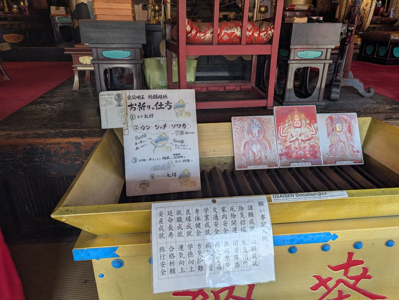金堂の正面に置かれた「お祈りの仕方」の案内と、仏さまの写真札