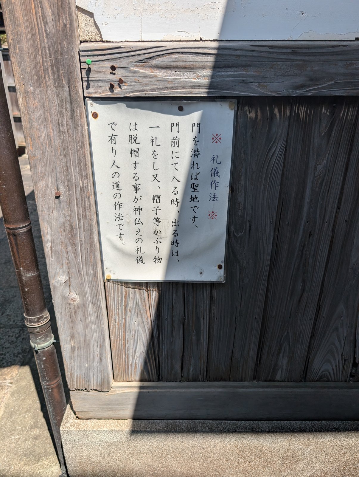 門の脇の掲示「礼儀作法」。門を潜れば聖地であり、入る時と出る時に一礼し、帽子などは脱ぐよう書かれている