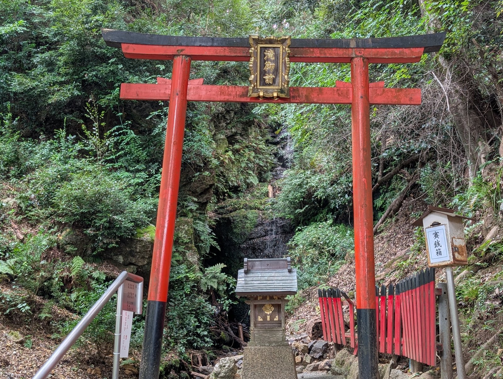 滝の手前に立つ朱塗りの鳥居