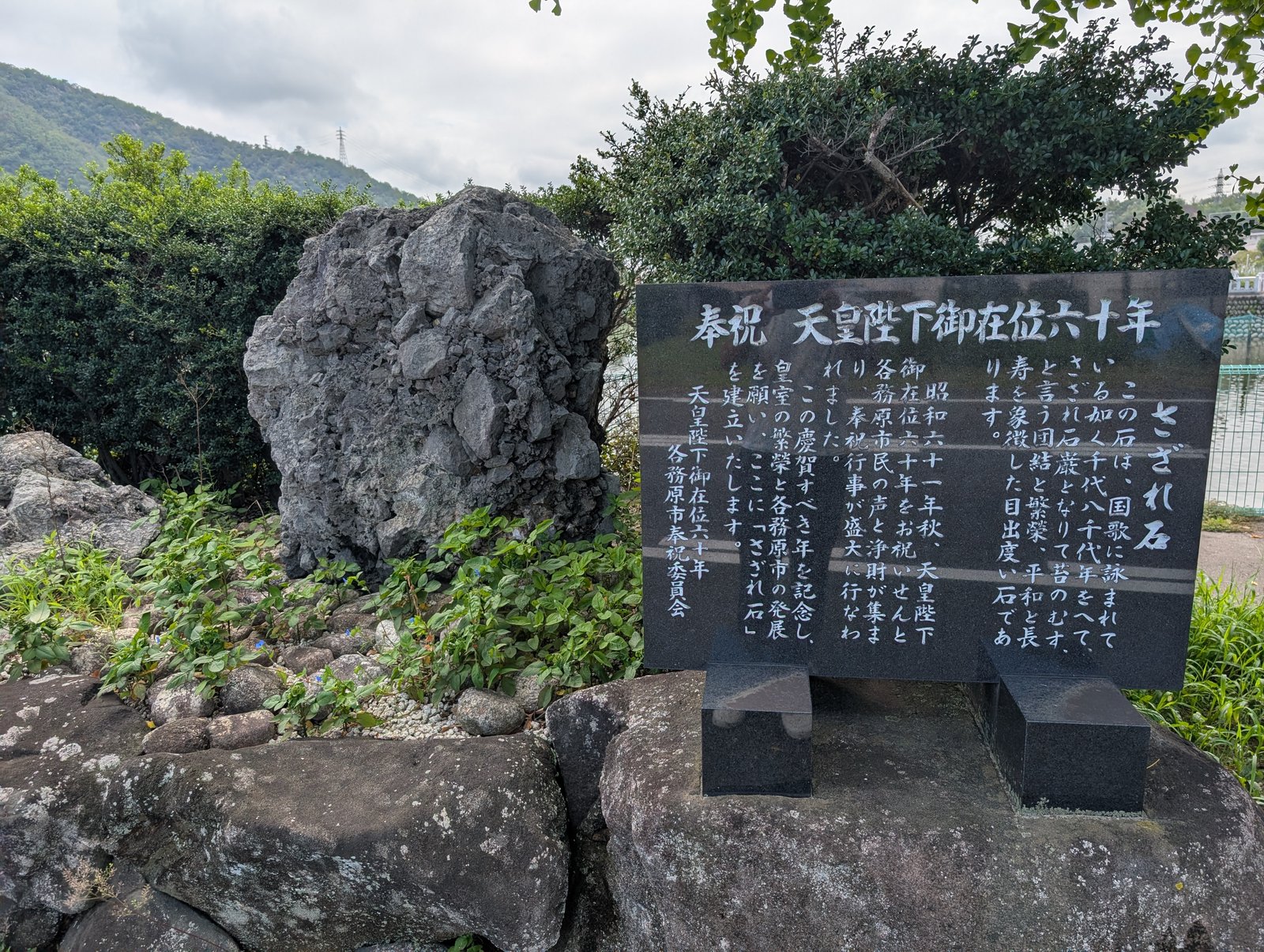 池のほとりのさざれ石と、右の由緒碑