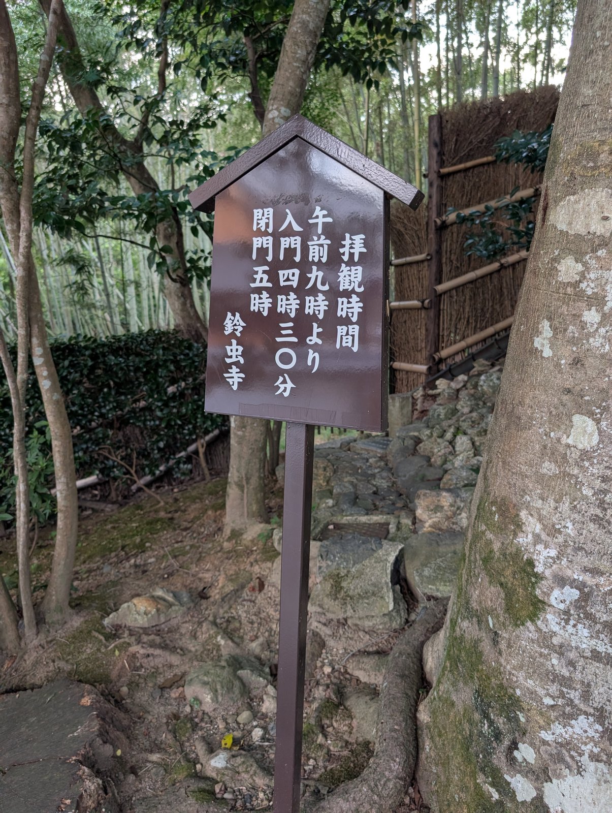 竹林の参道脇の立て札。「拝観時間 午前九時より 入門四時三〇分 閉門五時」
