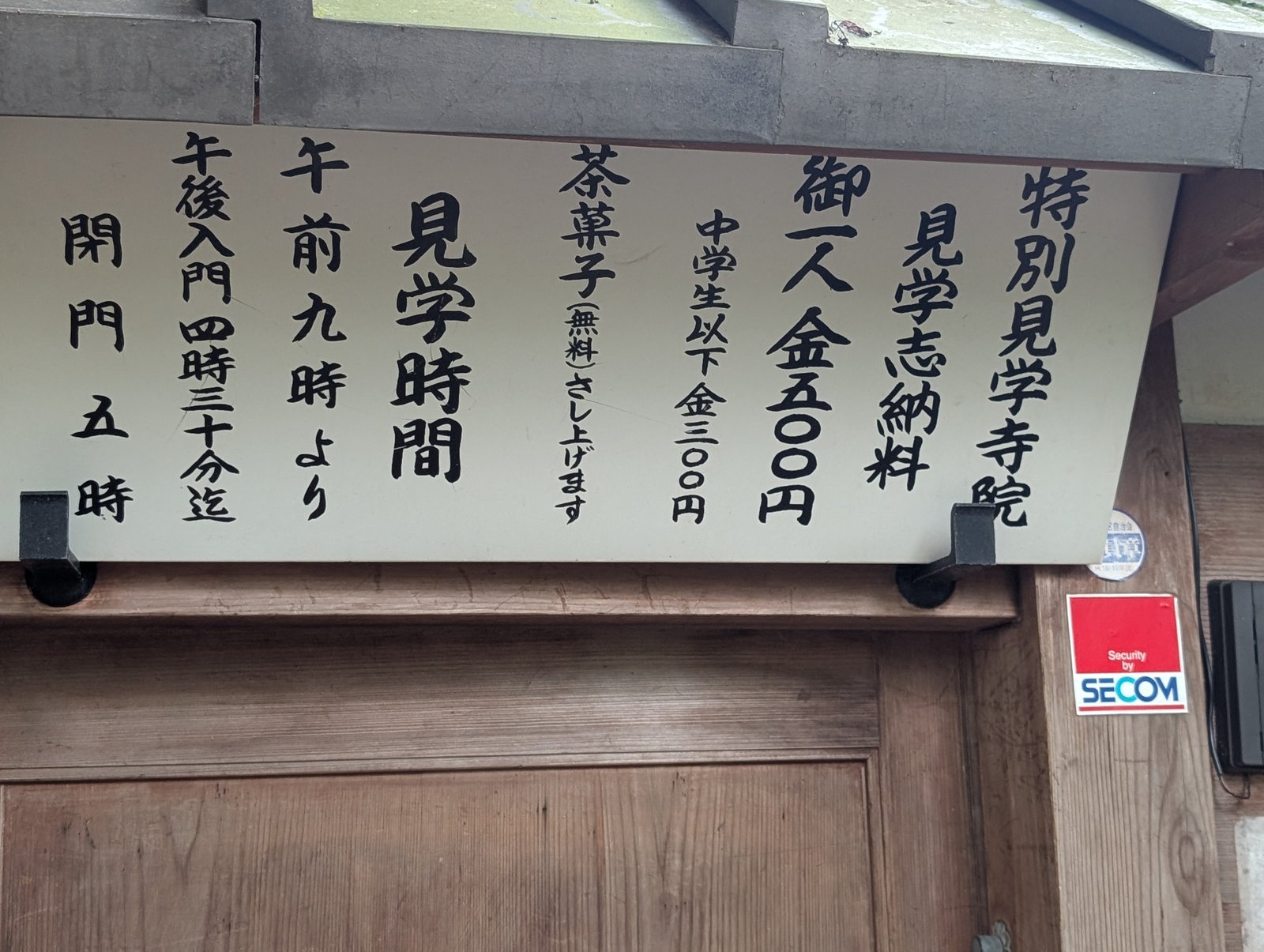 山門の掲示。見学志納料と見学時間が書かれている