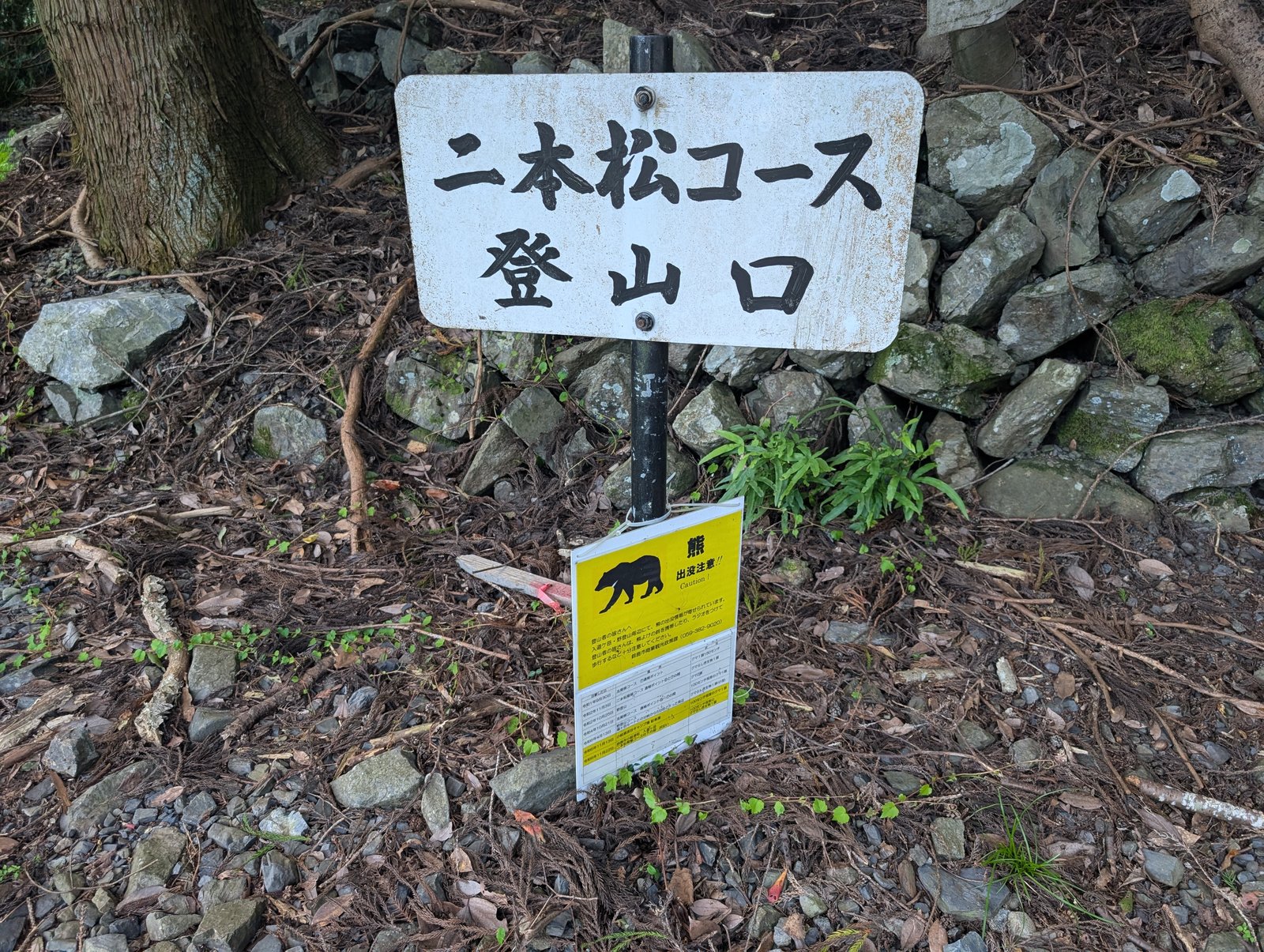 「二本松コース 登山口」の標識と、黄色い「熊 出没注意!!」