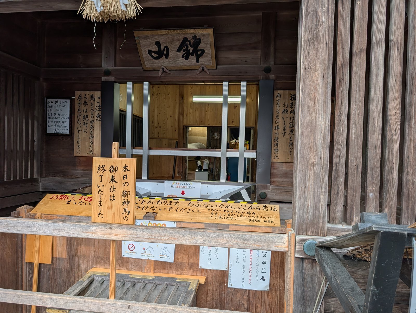 御神馬 錦山号の厩舎。手前に「本日の御神馬の御奉仕は終了いたしました」の立札（2026-09-05 撮影）
