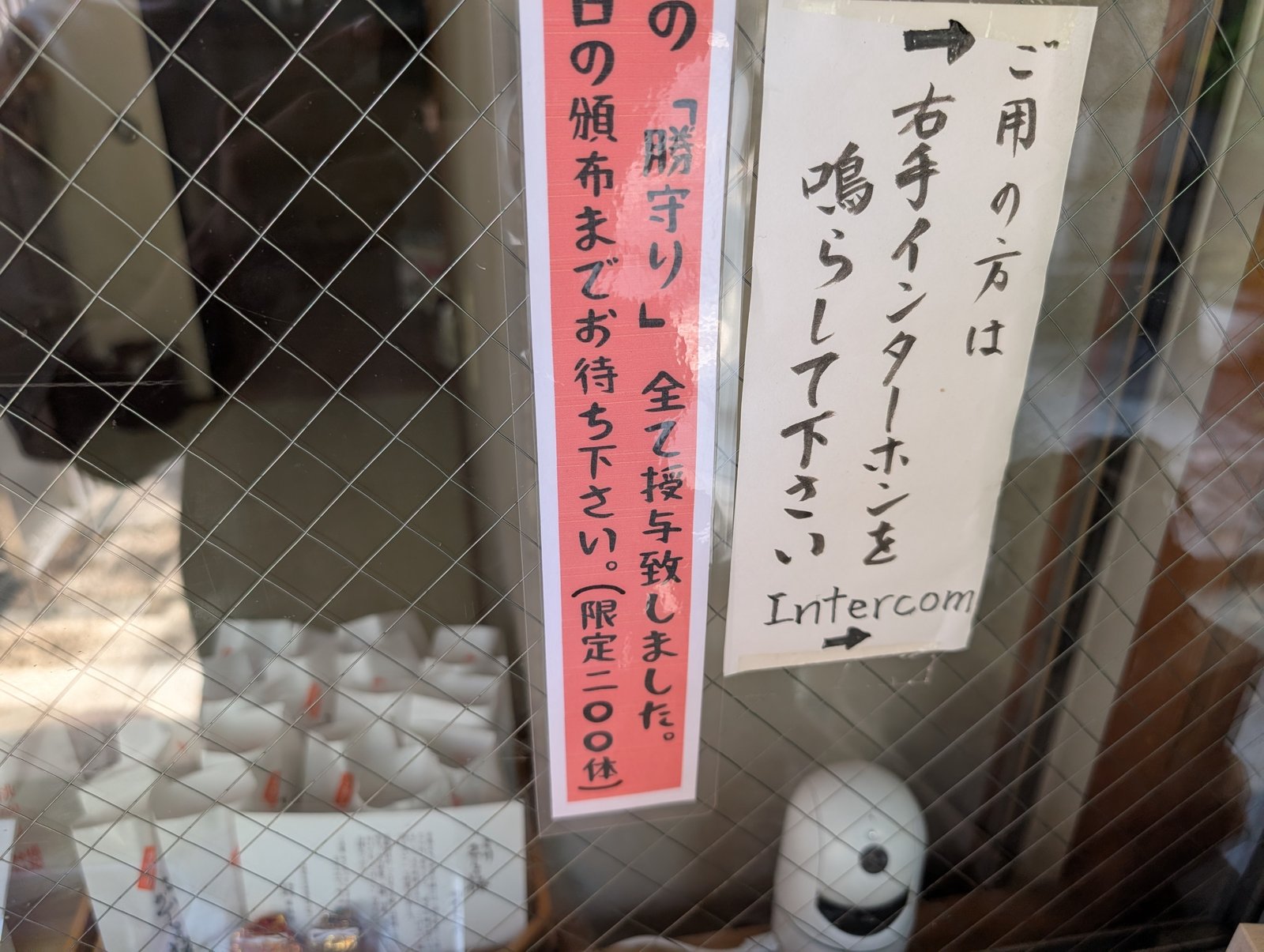 授与所の窓口。「ご用の方は右手インターホンを鳴らして下さい」と案内がある