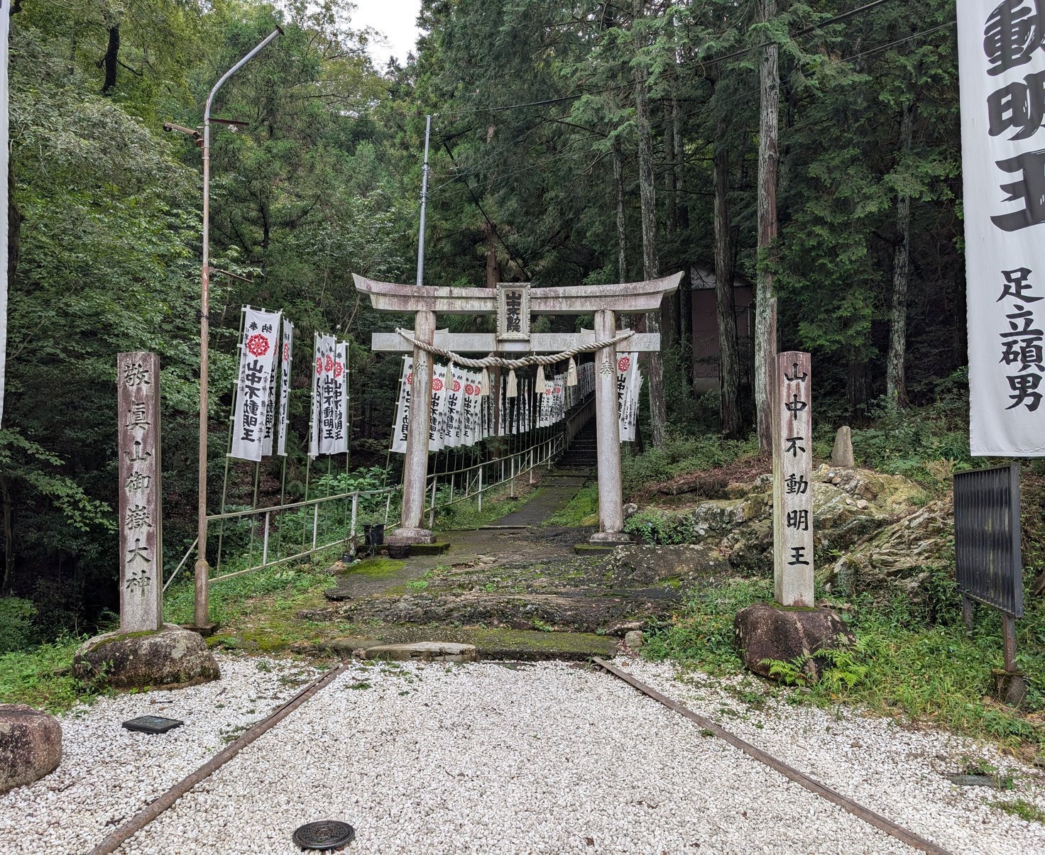 入口の石鳥居。扁額に「山中不動院」、左右の石標に「敬眞山御嶽大神」「山中不動明王」