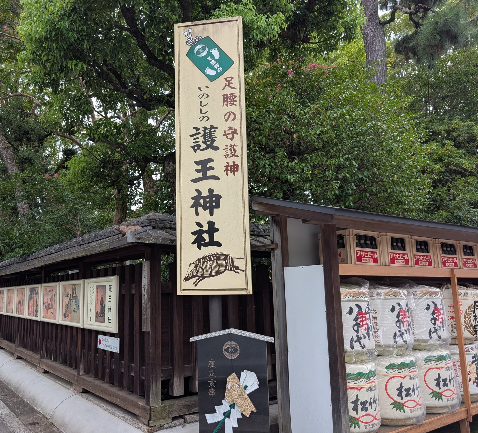社頭の看板「足腰の守護神 いのししの護王神社」と、脇に並ぶ酒樽