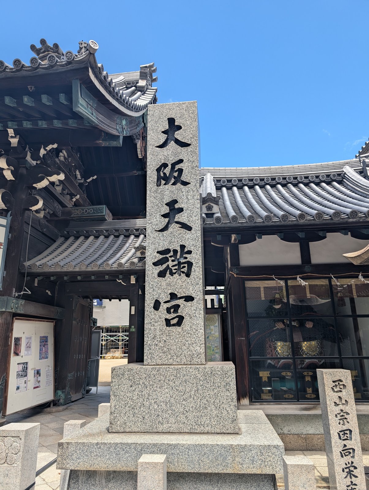 社号標。門の奥に本殿の素屋根が見える